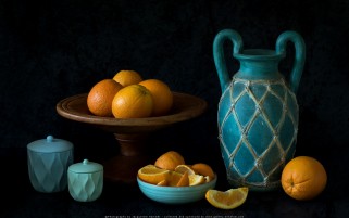 عکس زیبا و حرفه ای از چیدمان ظروف سفالی آبی فیروزه ای و پرتقال ها